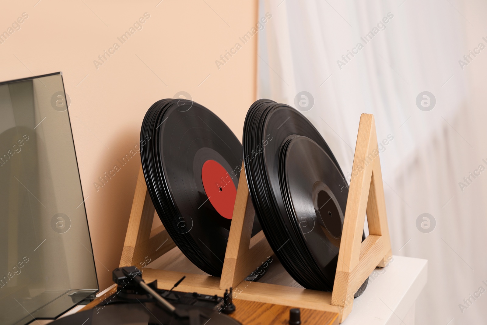 Photo of Vinyl records and player on white wooden table indoors