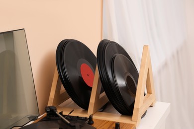 Vinyl records and player on white wooden table indoors