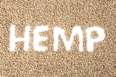 Word HEMP written on scattered seeds, top view