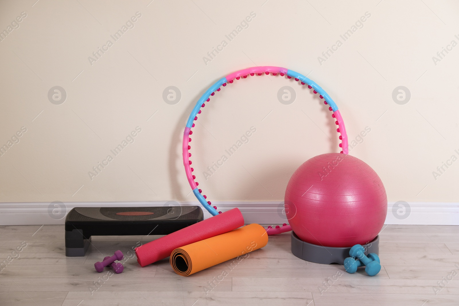 Photo of Different sports equipment near light wall in gym