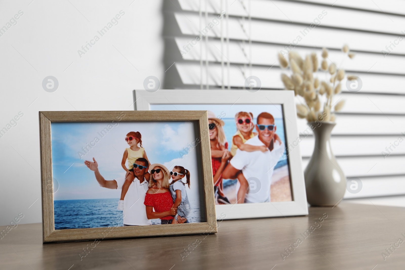 Photo of Frames with family photos on wooden table indoors