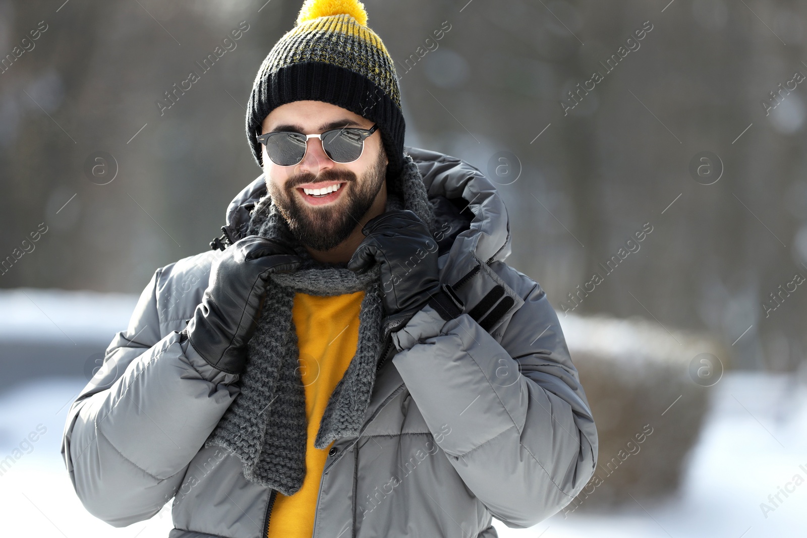 Photo of Portrait of handsome young man with sunglasses on winter day outdoors