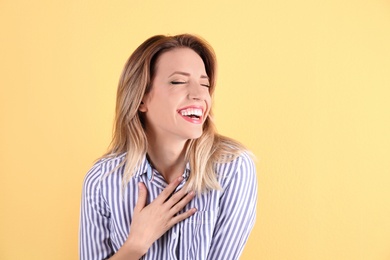 Photo of Portrait of beautiful laughing woman on color background