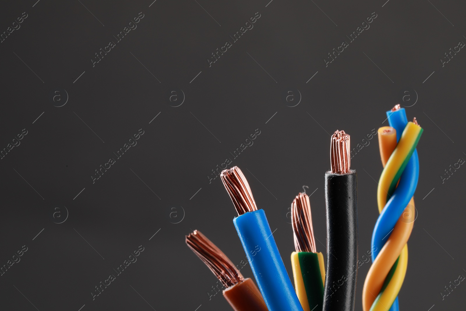 Photo of New colorful electrical wires on gray background, space for text