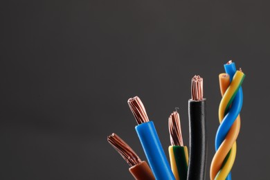 New colorful electrical wires on gray background, space for text