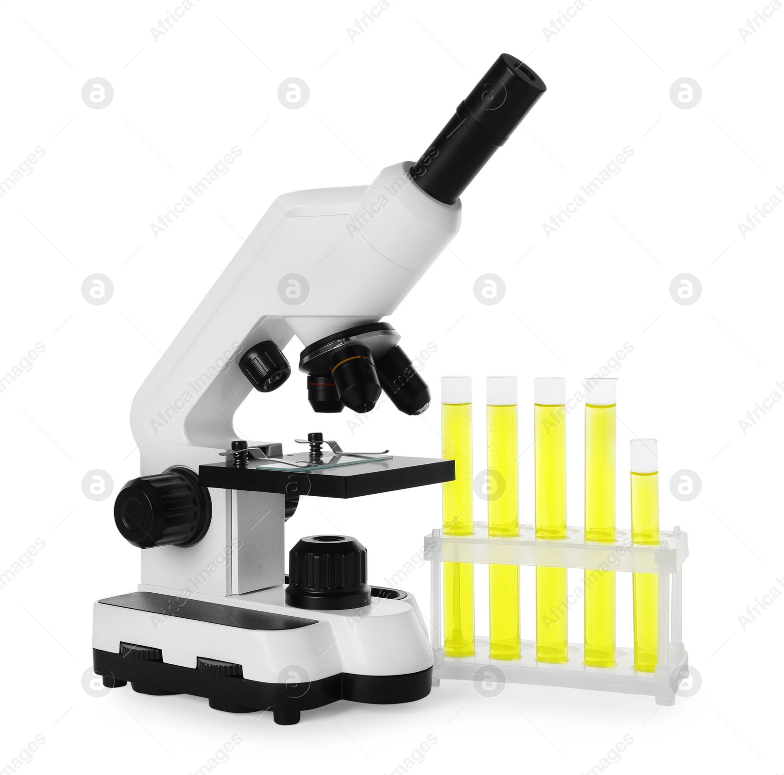 Photo of Test tubes with yellow liquid and microscope isolated on white