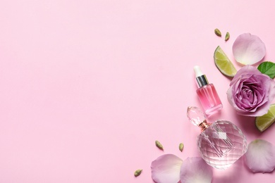Photo of Flat lay composition with elegant perfume on pink background, space for text