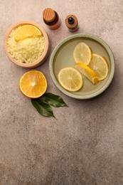 Photo of Flat lay composition with essential oil and lemons on grey textured table, space for text. Aromatherapy treatment