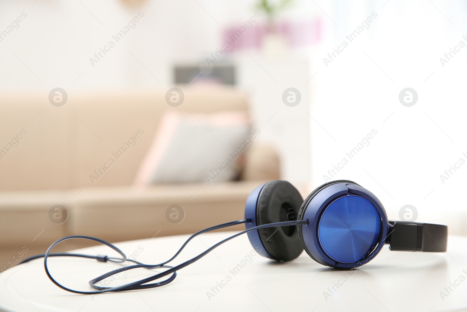 Photo of Stylish headphones on table indoors. Space for text