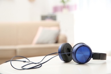 Photo of Stylish headphones on table indoors. Space for text