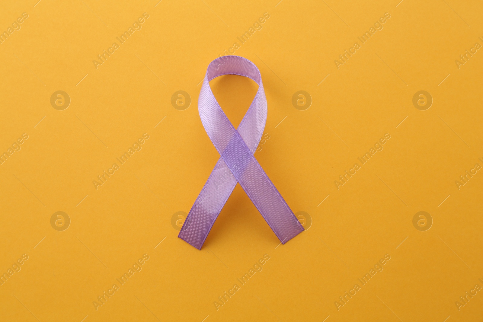 Photo of Violet awareness ribbon on orange background, top view