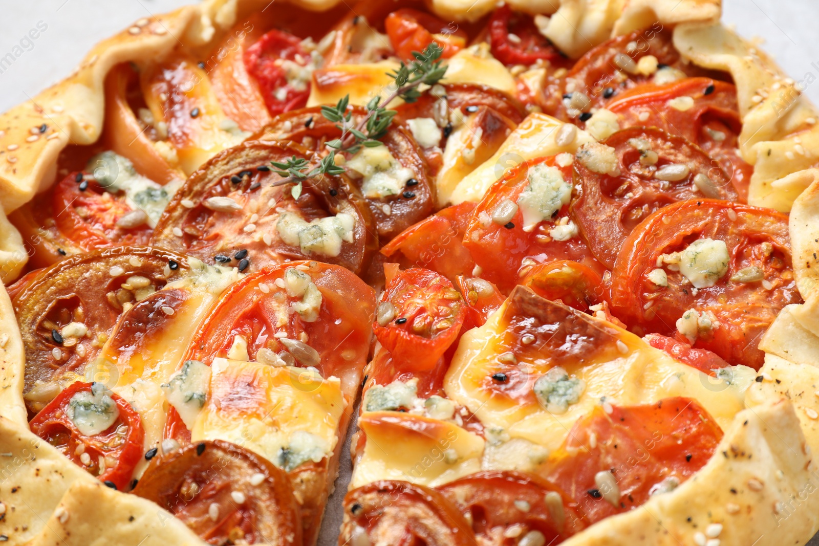 Photo of Tasty galette with tomato and cheese (Caprese galette) on parchment, closeup