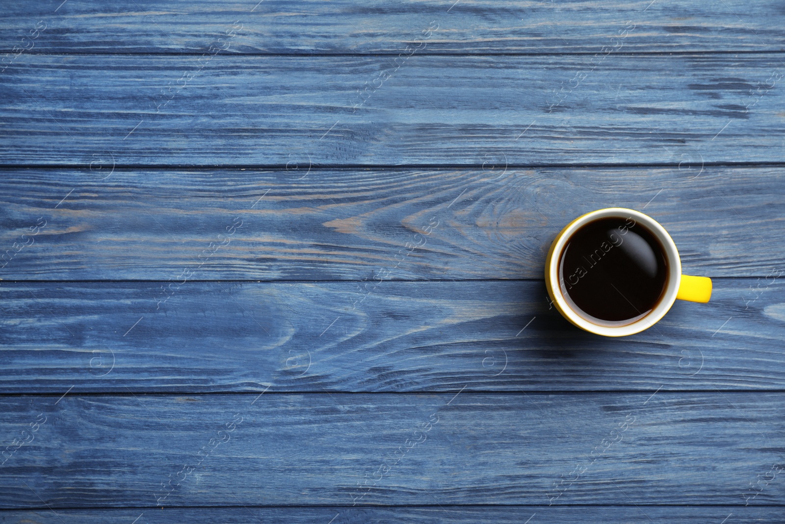 Photo of Ceramic cup with hot aromatic coffee on wooden background, top view