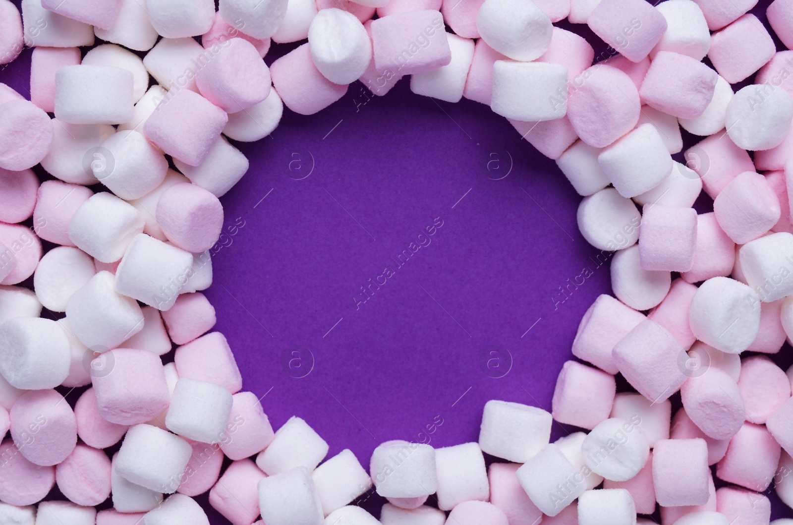 Photo of Delicious marshmallows on purple background, flat lay. Space for text