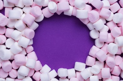 Photo of Delicious marshmallows on purple background, flat lay. Space for text