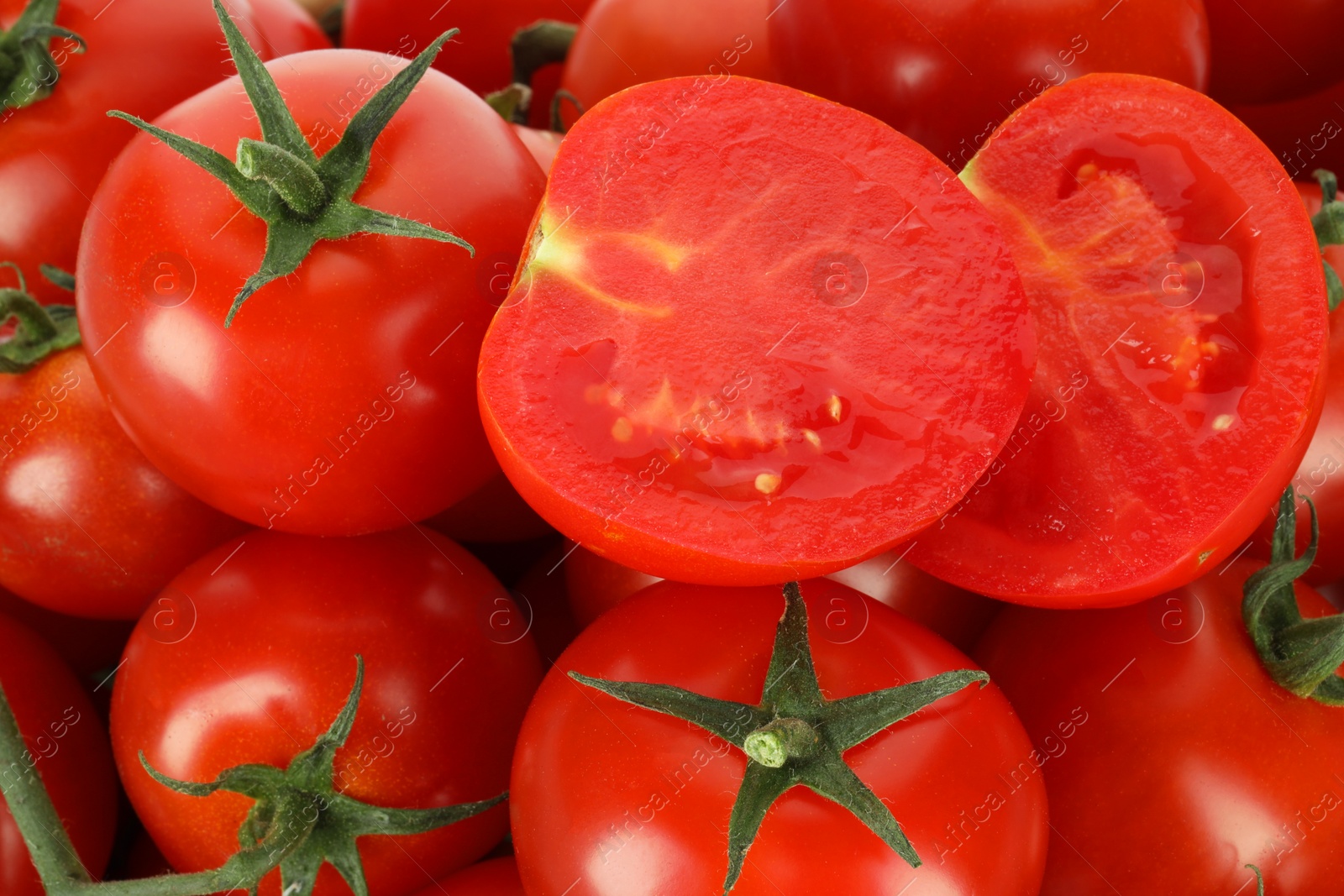 Photo of Whole and cut cherry tomatoes as background, closeup