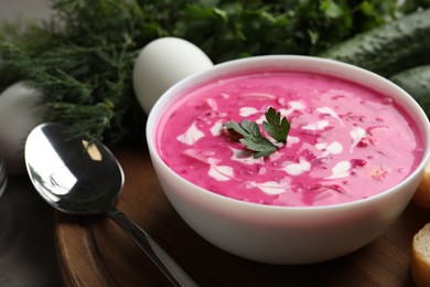 Photo of Delicious cold summer beet soup on wooden board, closeup