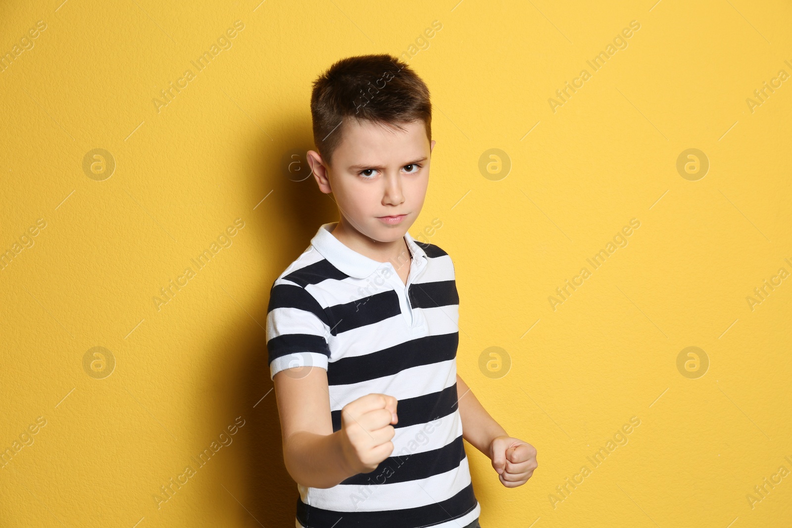 Photo of Portrait of emotional preteen boy on yellow background