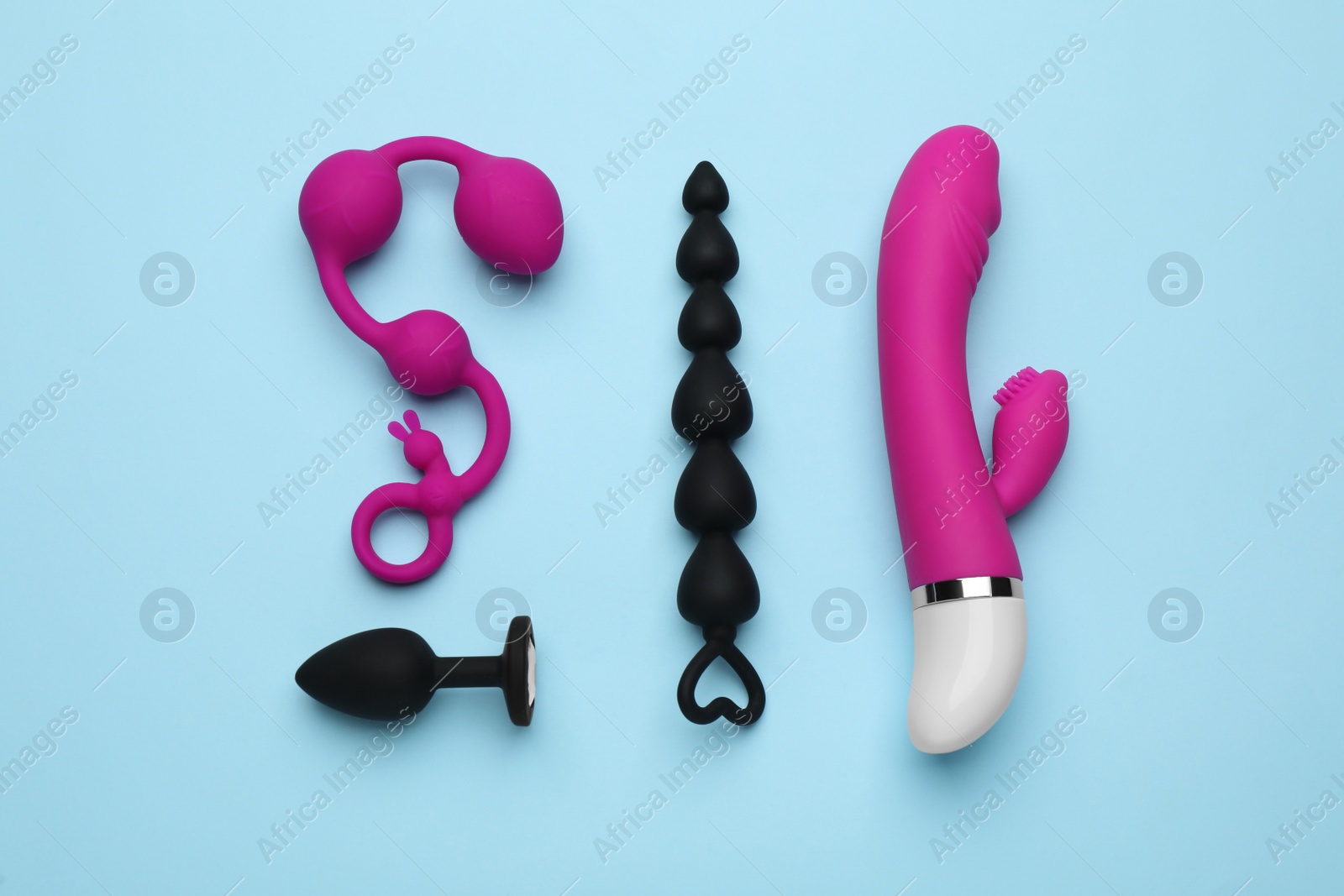 Photo of Sex toys on light blue background, flat lay