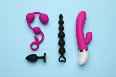 Photo of Sex toys on light blue background, flat lay