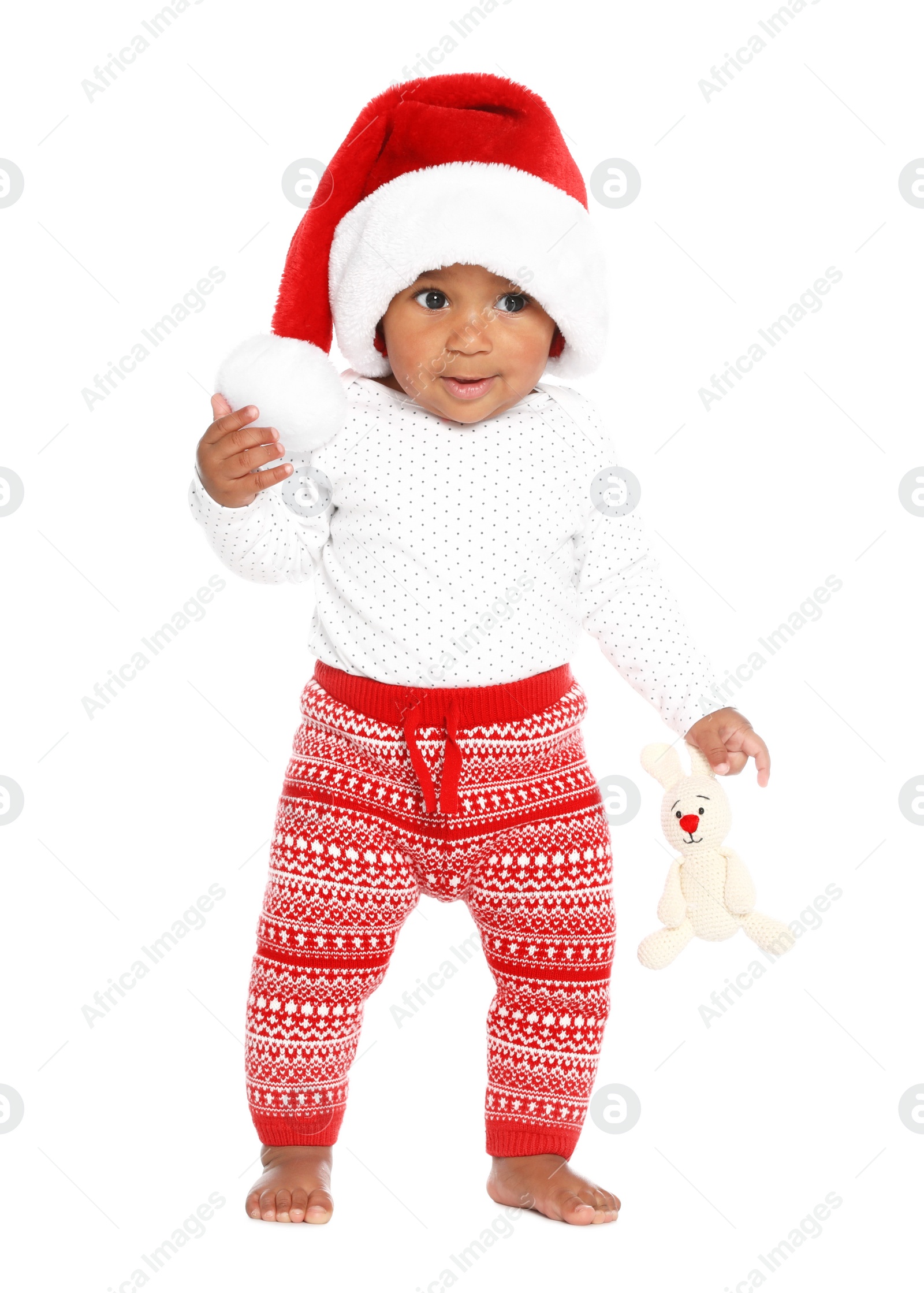 Photo of Festively dressed African-American baby with toy on white background. First Christmas