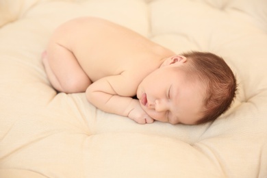 Adorable newborn baby sleeping on bed