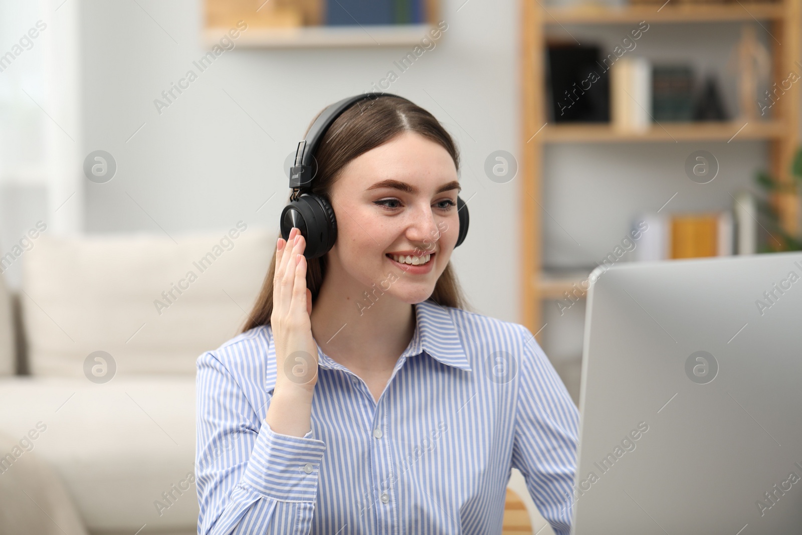 Photo of E-learning. Young woman studying with computer during online lesson indoors.