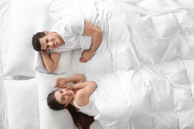 Photo of Lovely young couple resting on large bed, above view