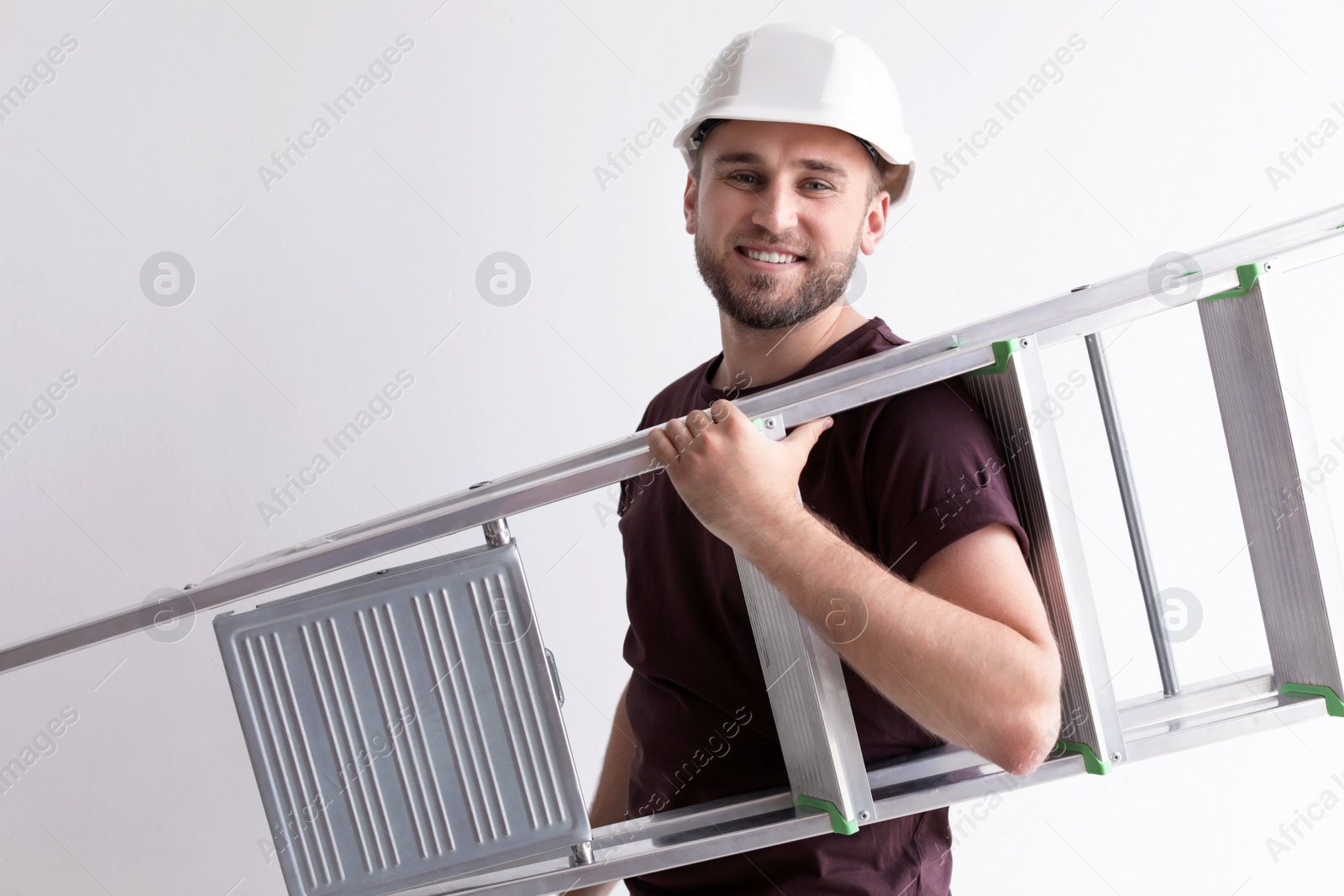 Photo of Young working man with ladder on white background