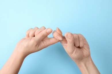 Photo of Woman showing word friend on color background, closeup. Sign language