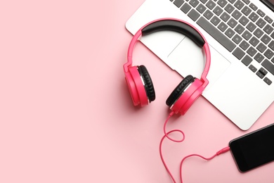 Modern headphones, phone and laptop on color background, flat lay. Space for text