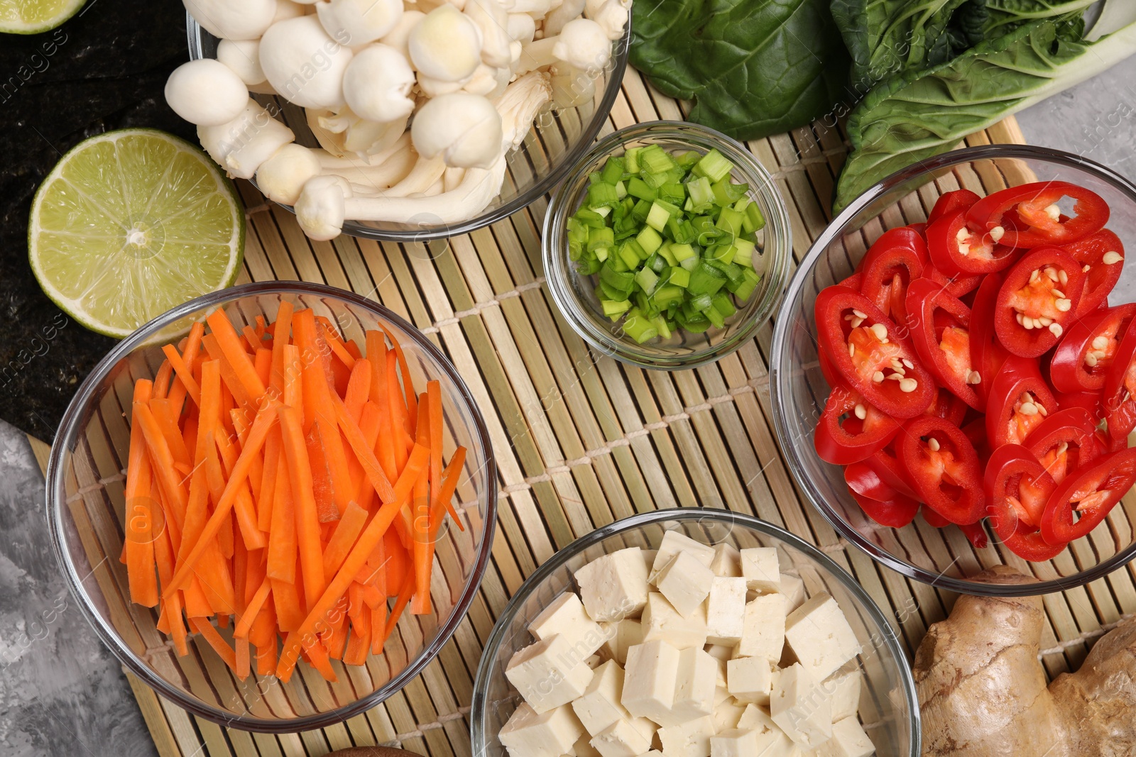 Photo of Cooking delicious ramen soup. Different ingredients on table, flat lay