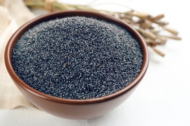 Photo of Poppy seeds in bowl on white table