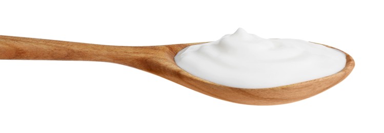 Photo of One wooden spoon with sour cream isolated on white