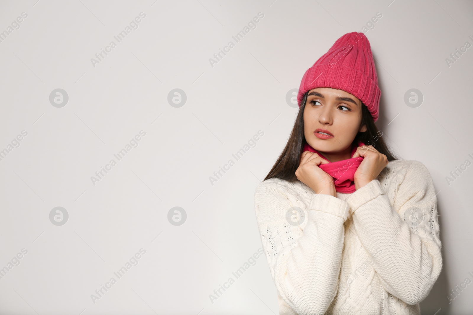 Photo of Woman wearing stylish winter sport clothes on light grey background, space for text