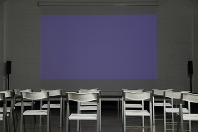 Photo of Empty conference room with projection screen and chairs