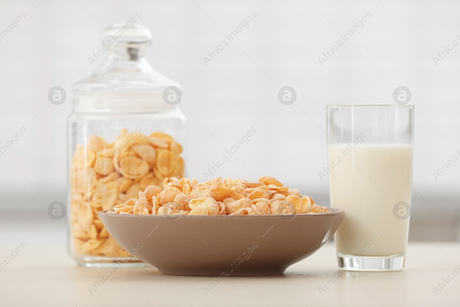 Photo of Cornflakes with glass of milk on kitchen table