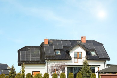 Photo of House with installed solar panels on roof. Alternative energy