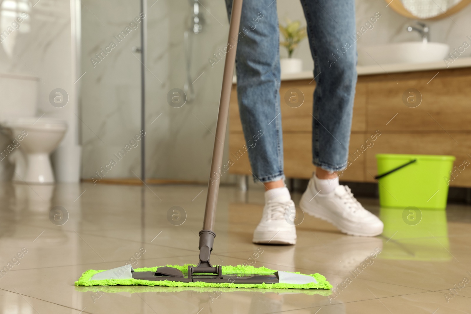 Photo of Woman cleaning floor with mop at home, closeup