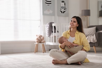 Photo of Young woman with her sleeping baby on floor at home