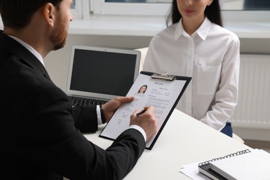Photo of Human resources manager conducting job interview with applicant in office, closeup