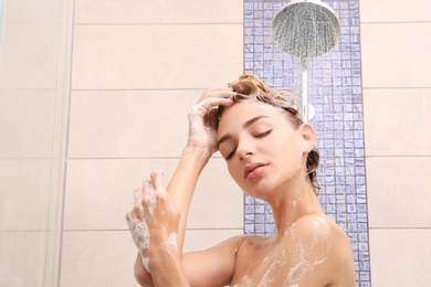 Photo of Beautiful young woman taking shower at home