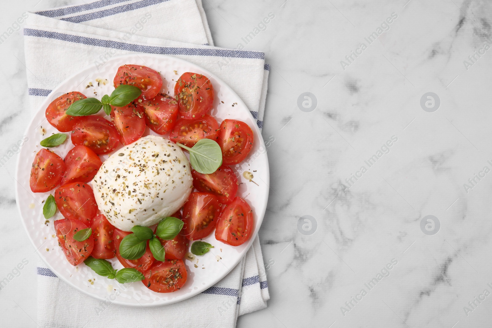 Photo of Tasty salad Caprese with mozarella, tomatoes and basil on white marble table, top view. Space for text
