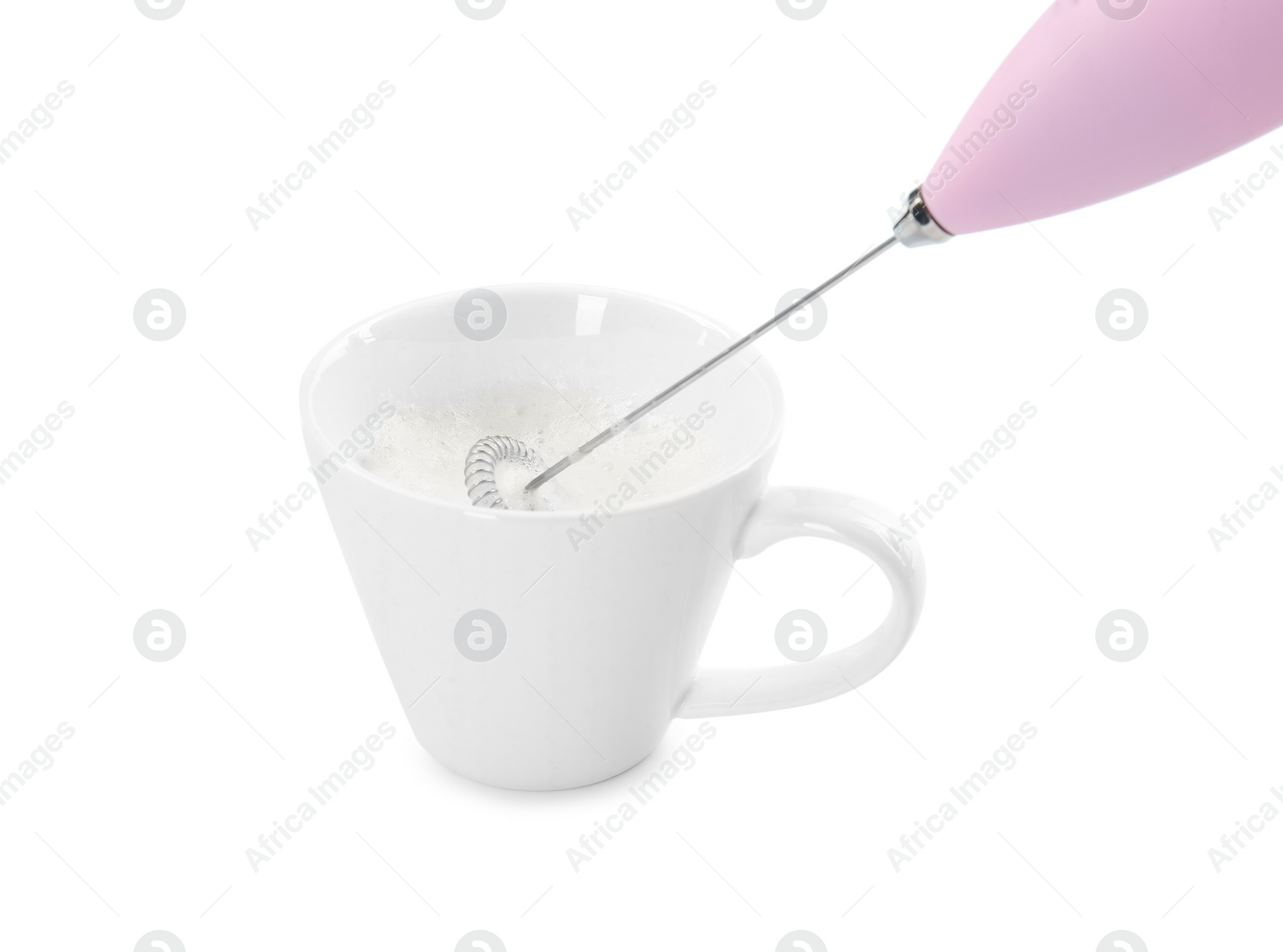 Photo of Whisking milk in cup with mini mixer (frother wand) isolated on white