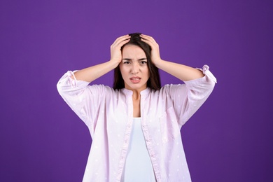 Photo of Portrait of stressed young woman on purple background