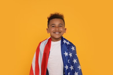 Photo of 4th of July - Independence Day of USA. Happy boy with American flag on yellow background