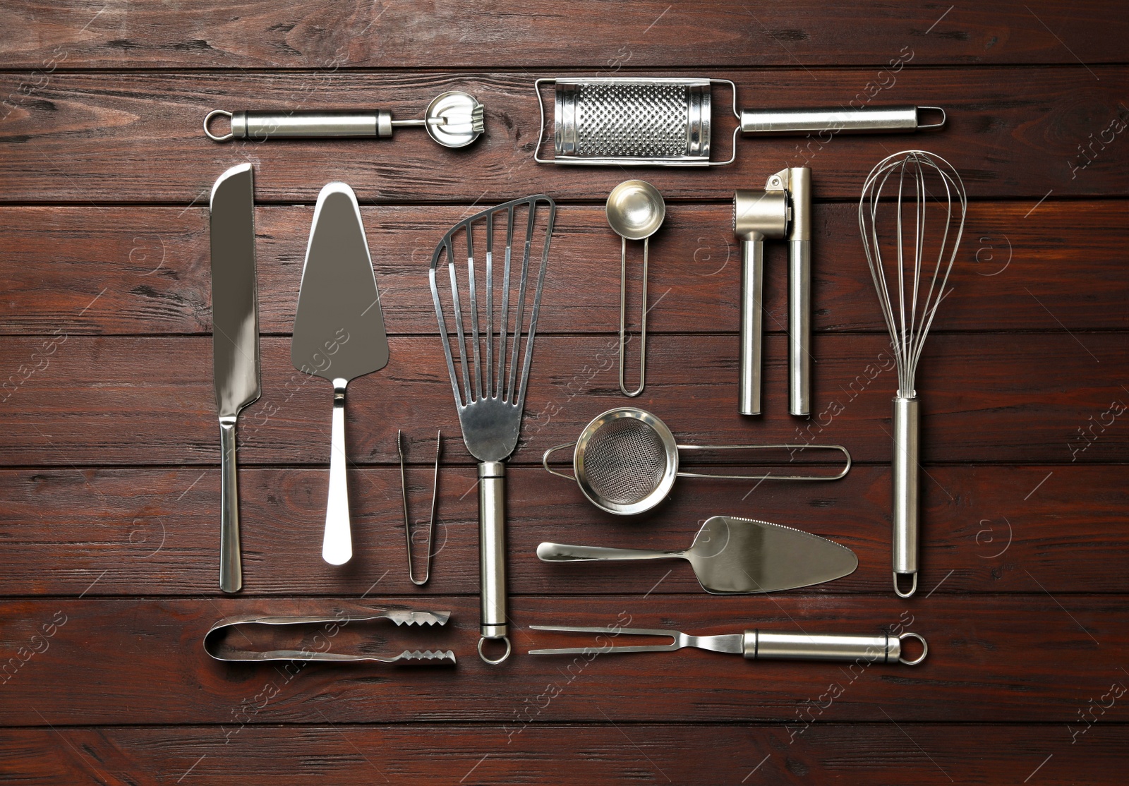 Photo of Set of modern cooking utensils on brown wooden table, flat lay