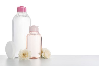 Micellar water and roses on table against white background. Space for text