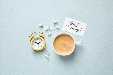 Photo of Flat lay composition with message GOOD MORNING and coffee on light blue background