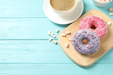 Delicious glazed donuts on blue wooden table, above view. Space for text